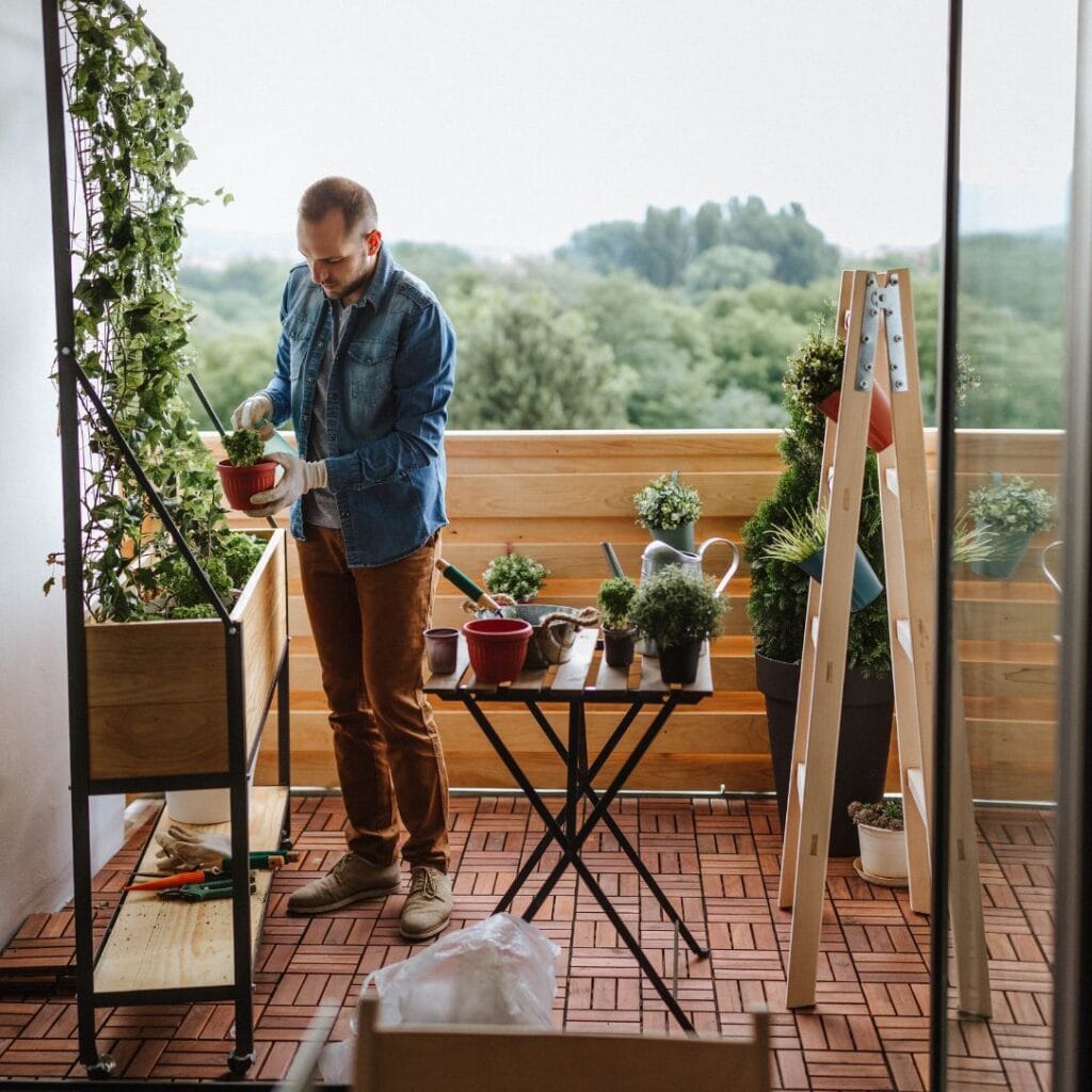 A smiling person gardening on a sunny balcony with easy-to-grow plants like herbs and flowers, using a gardening eBook nearby. Bright, welcoming atmosphere perfect for beginners.